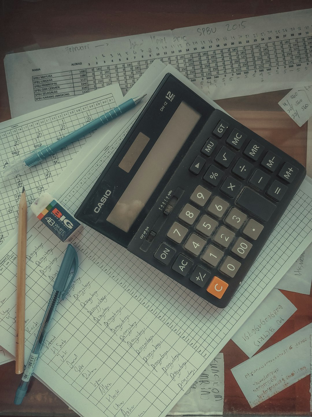 a-calculator-sitting-on-top-of-a-pile-of-papers-741ishluyhk